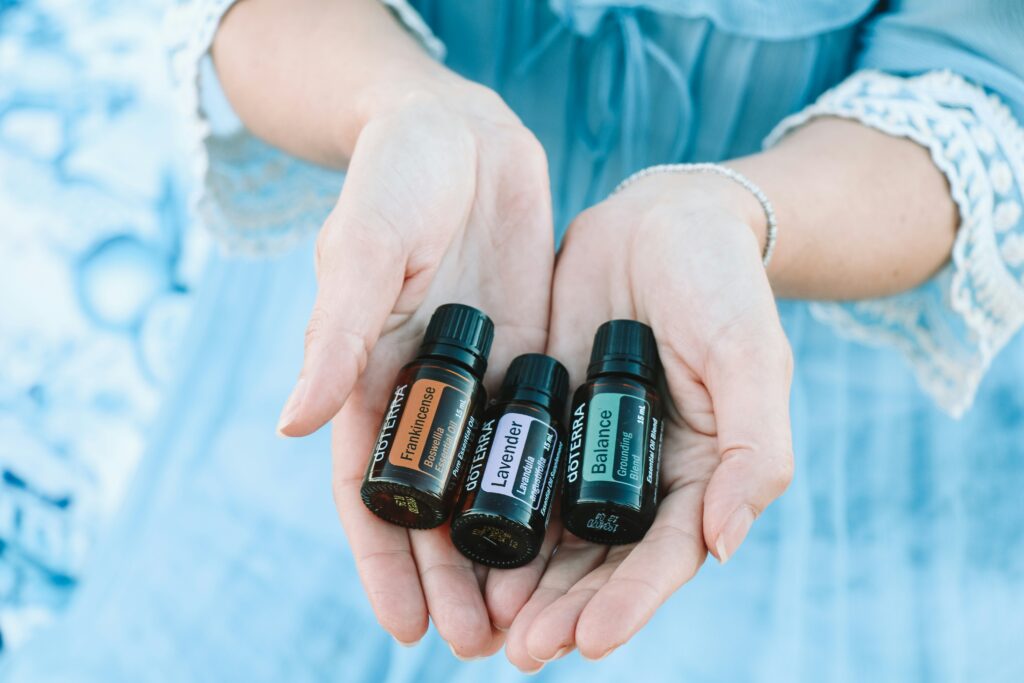 Hands holding several essential oil bottles, highlighting essential oils benefits for emotional balance, relaxation, and holistic wellness.