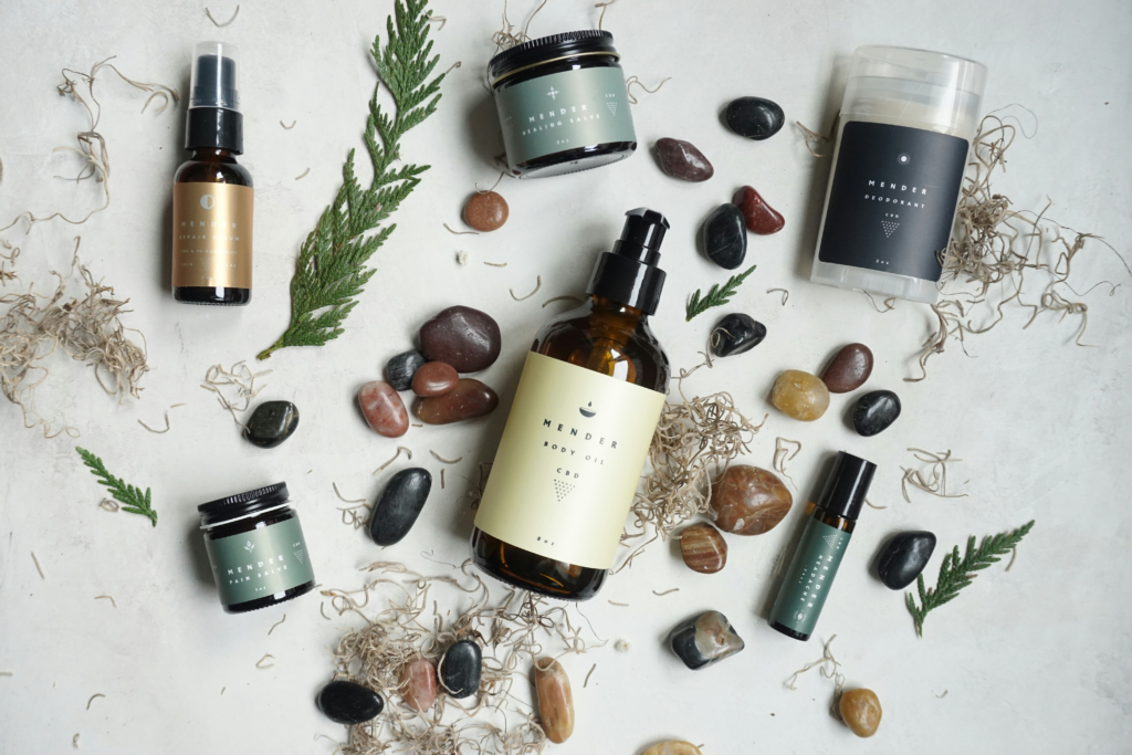 Natural wellness products and amber bottles arranged with herbs and smooth stones on a light surface, creating a calm holistic self-care scene.