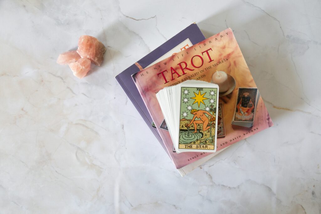 A tarot deck placed on spiritual books alongside crystals, symbolizing reflection, learning, and intuitive exploration.