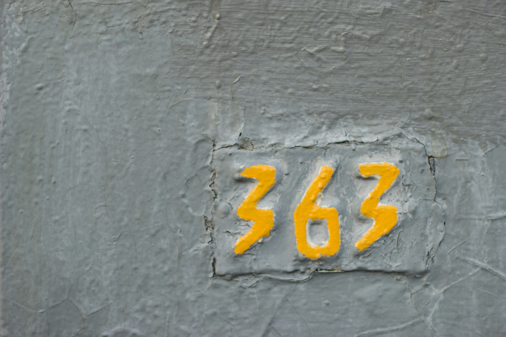 Yellow painted number 363 on a textured wall, illustrating how numbers appear in everyday life and connect to the numerology life path number system.