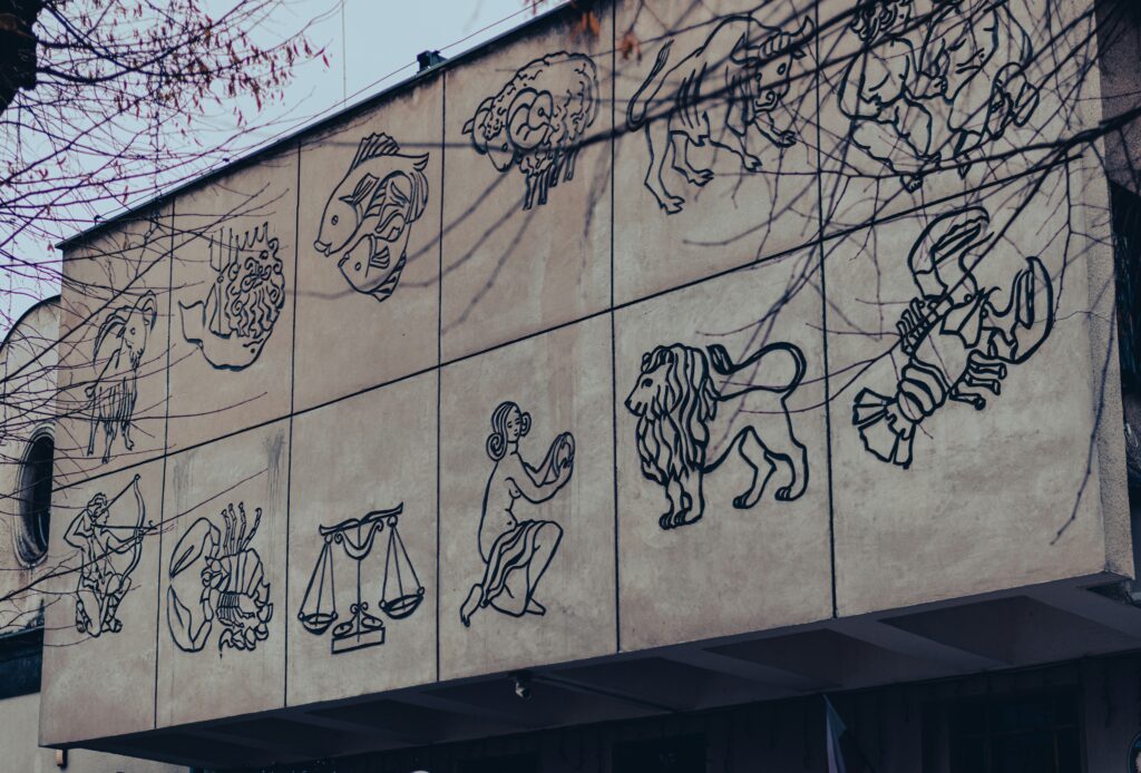 llustrations of zodiac signs displayed on a building wall, representing astrology, symbolism, and the connection between human traits and cosmic patterns.